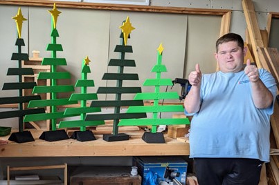 Josh giving thumbs up beside a table on which several green painted