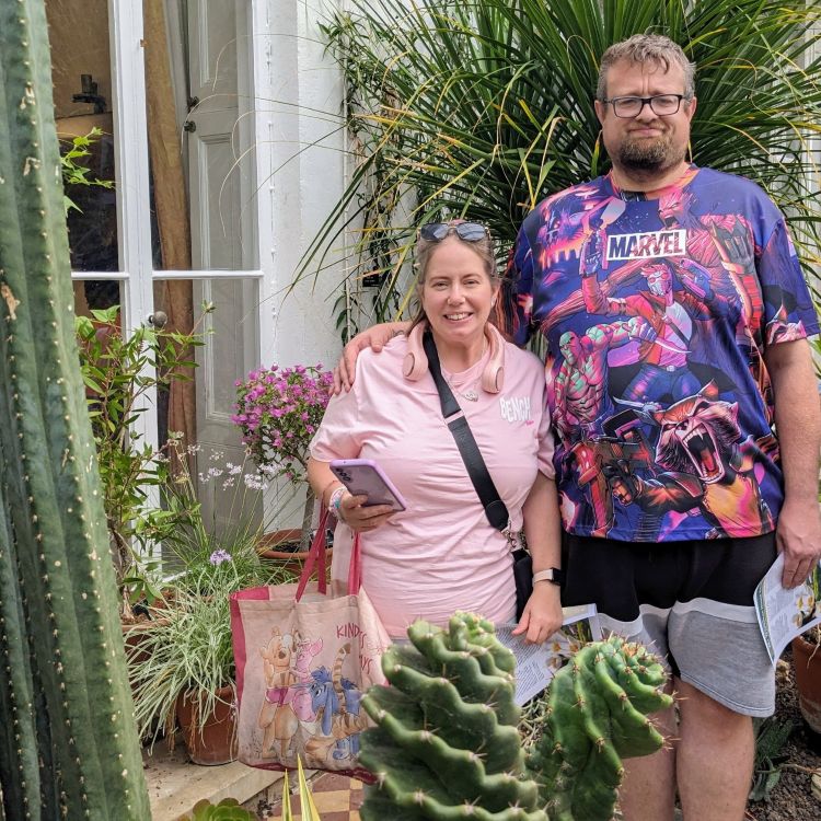 A woman and a man standing amongst some potted plants