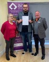Jason Baker receives his certificate from Mayor Christine Burgess and Chair of Grange Farm Trust Trevor Johnson
